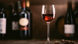 Wine glass and bottles on a wooden table. 